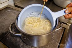 Отваренная лапша откидывается на дуршлаг, промывае...