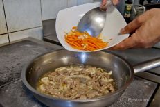 Мясо и лук на сковороде соединяются с морковью и ч...